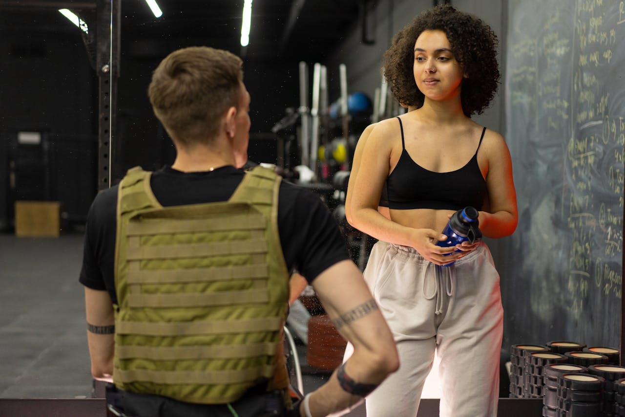 services-02 A personal trainer and client engage in conversation at a gym, highlighting fitness and training concepts.